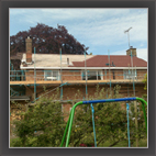 Scaffolded house with new tiled roof in progress